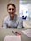 Smiling professional assisting a client with tax documents in a bright office.