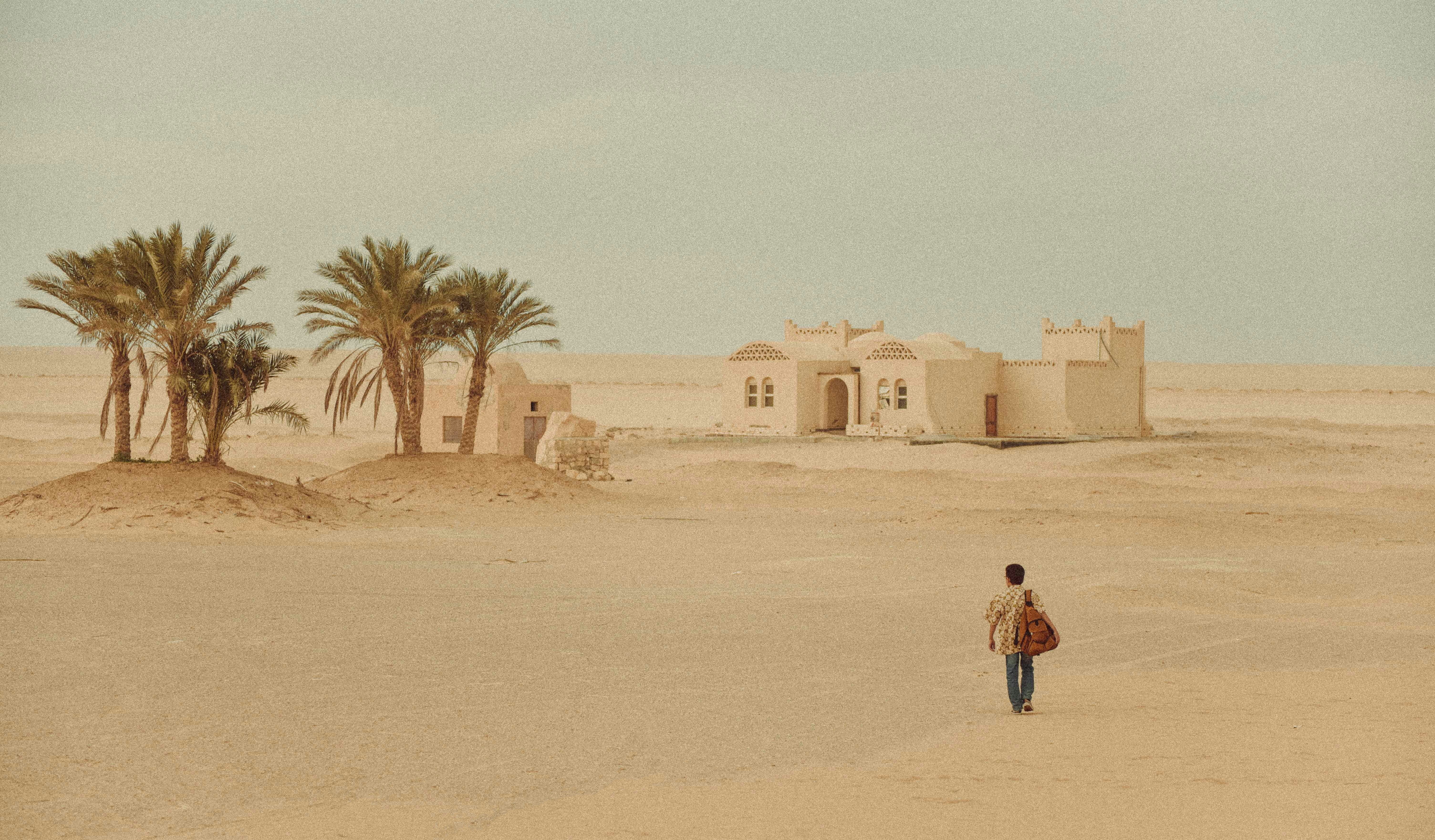 woman in red jacket walking on sand during daytime