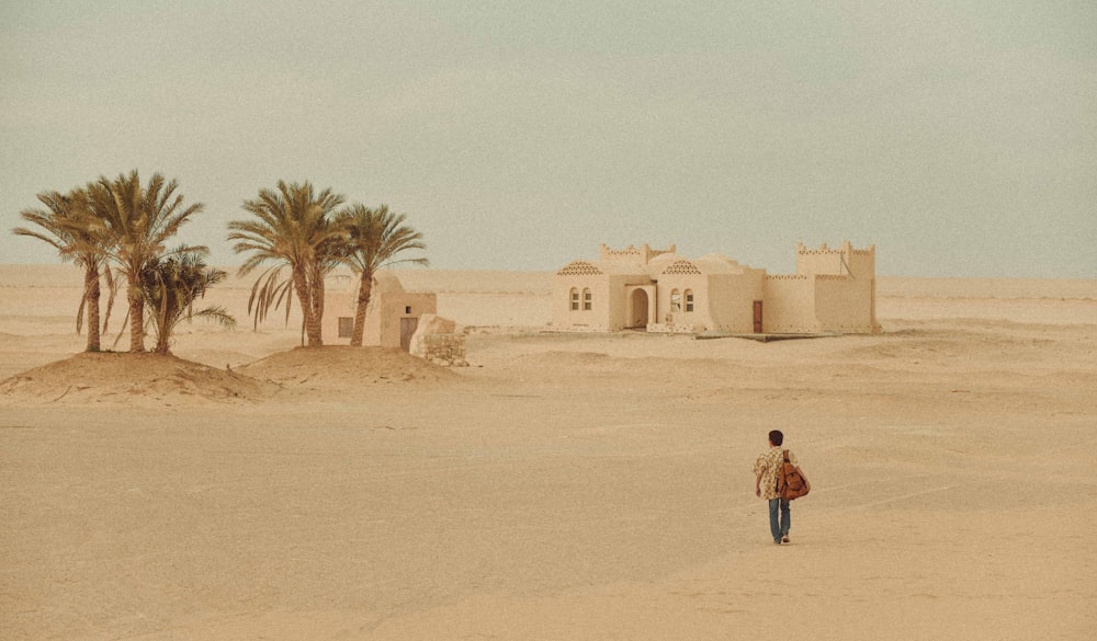 woman in red jacket walking on sand during daytime