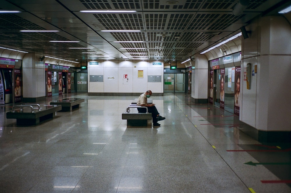 man in white shirt sitting on black bench