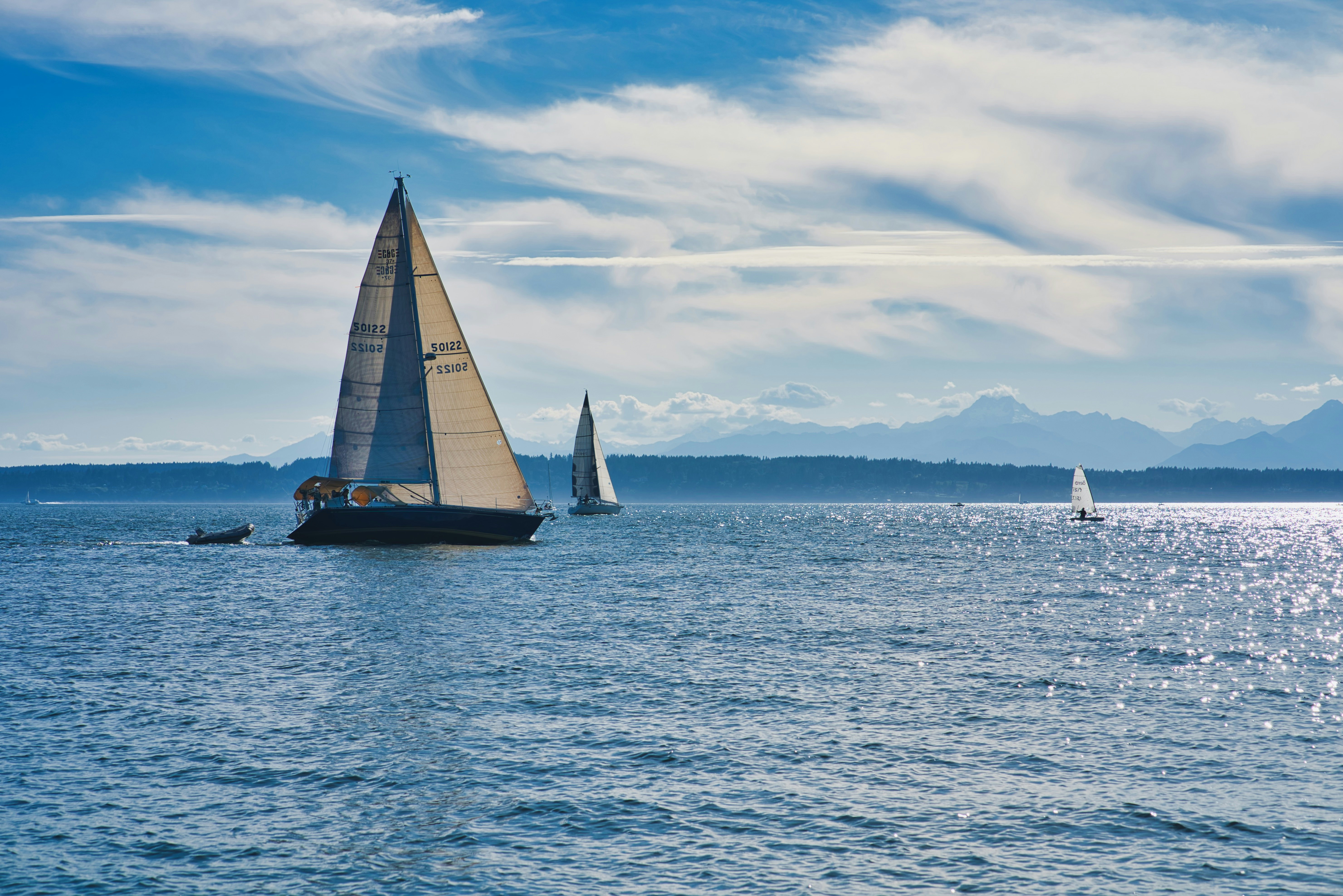 white sail boat on sea under blue sky during daytime