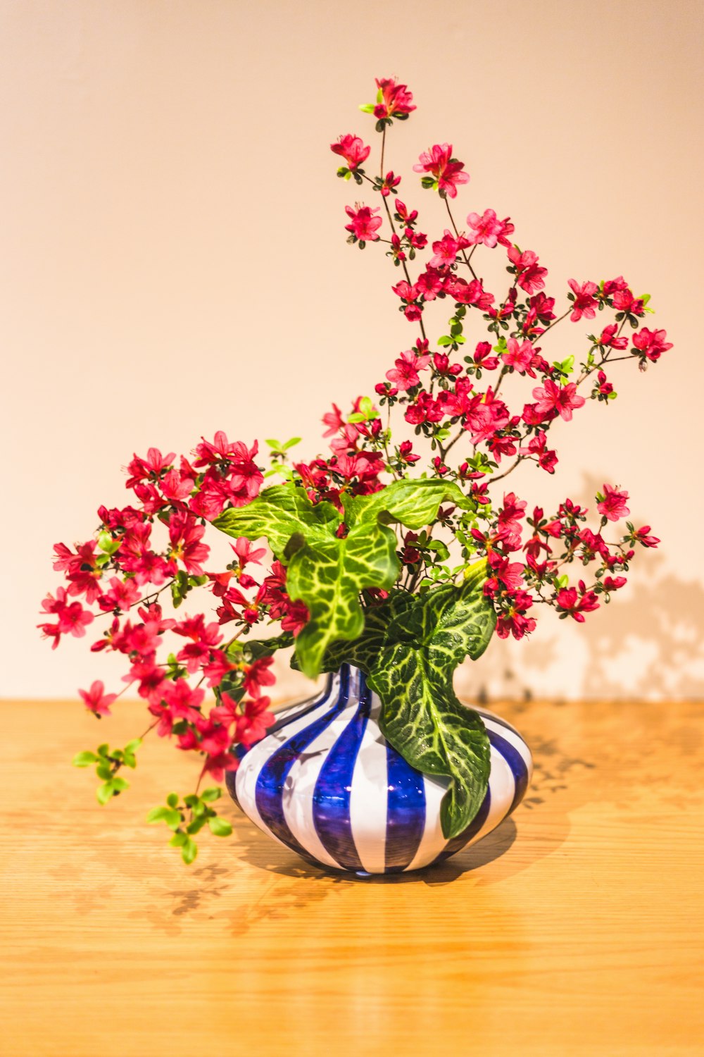 pink and green flower in blue and white ceramic vase