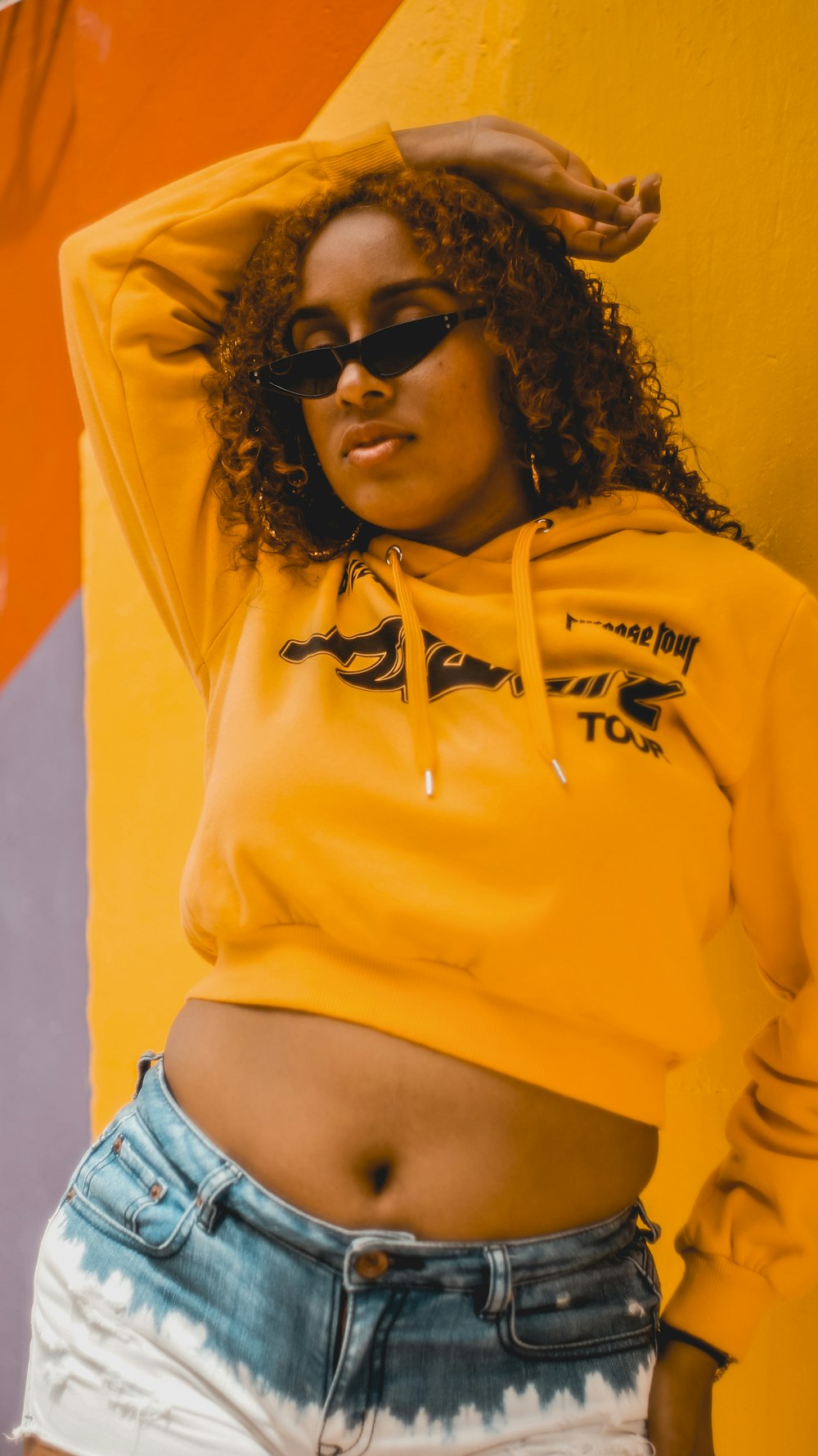 woman in yellow and blue hoodie wearing black sunglasses