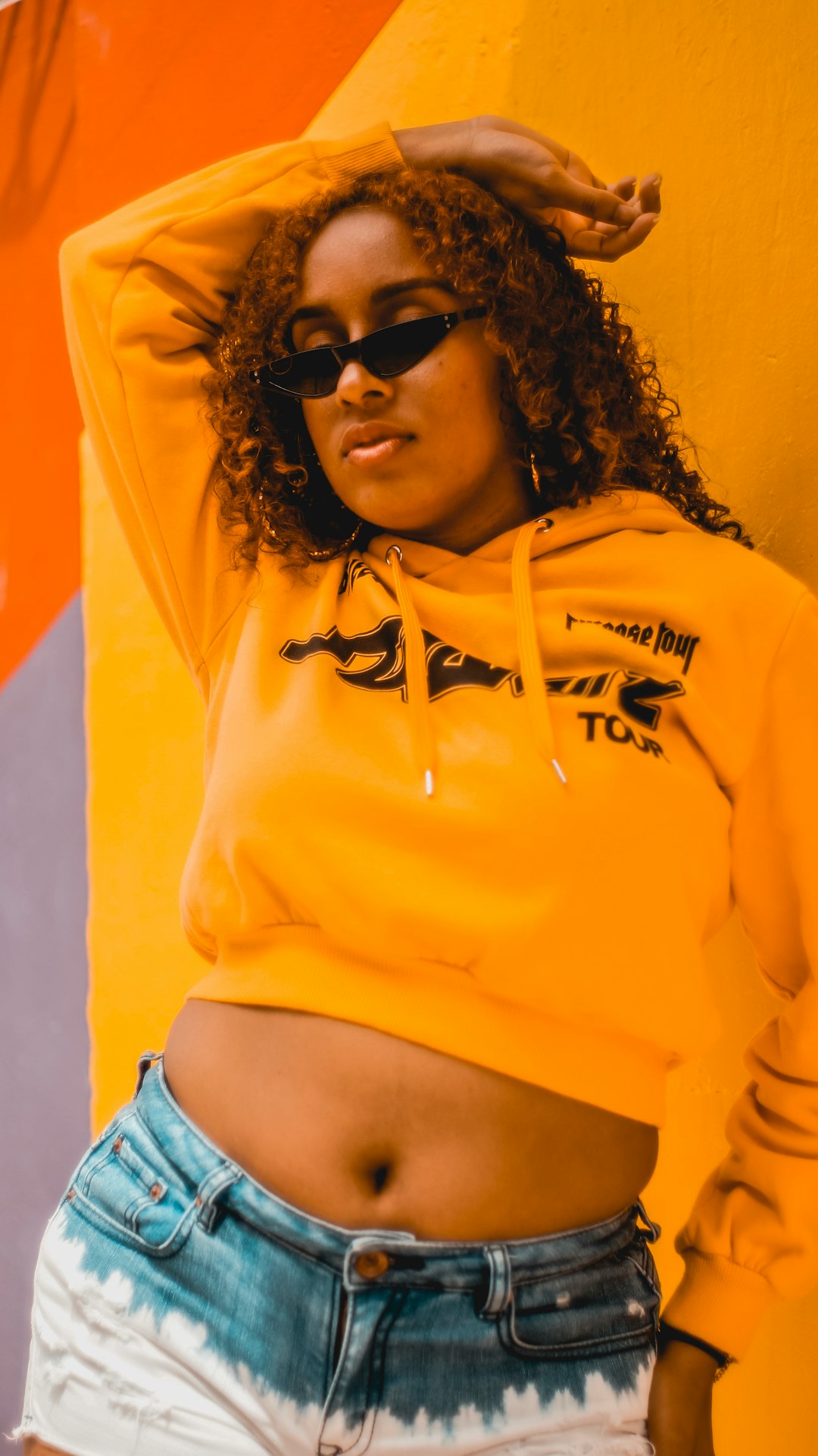 woman in yellow and blue hoodie wearing black sunglasses