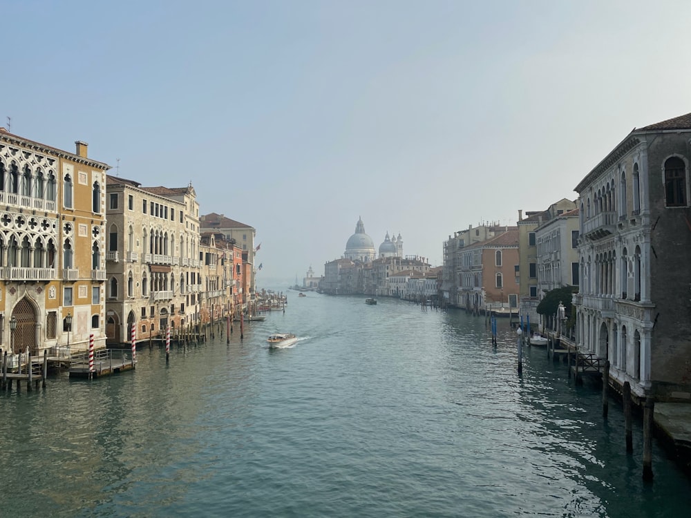 barca bianca sul fiume tra gli edifici durante il giorno