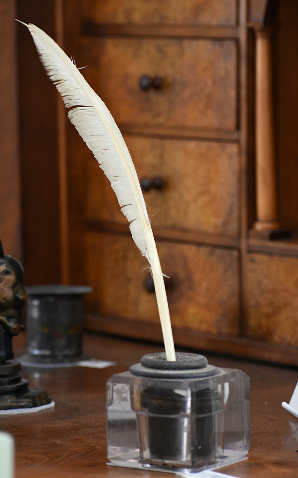 white feather on black metal cup