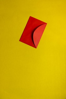 A red envelope is placed diagonally on a yellow background.