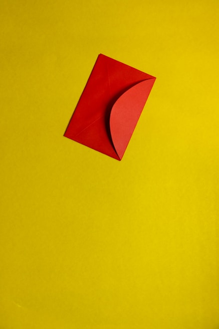 A red envelope is placed diagonally on a yellow background.
