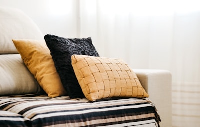 brown throw pillow on white and blue bed linen