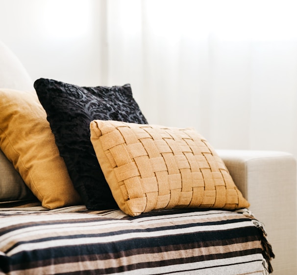 brown throw pillow on white and blue bed linen