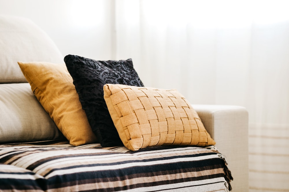 brown throw pillow on white and blue bed linen