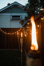 A cozy backyard illuminated by warm, custom outdoor lighting at dusk.