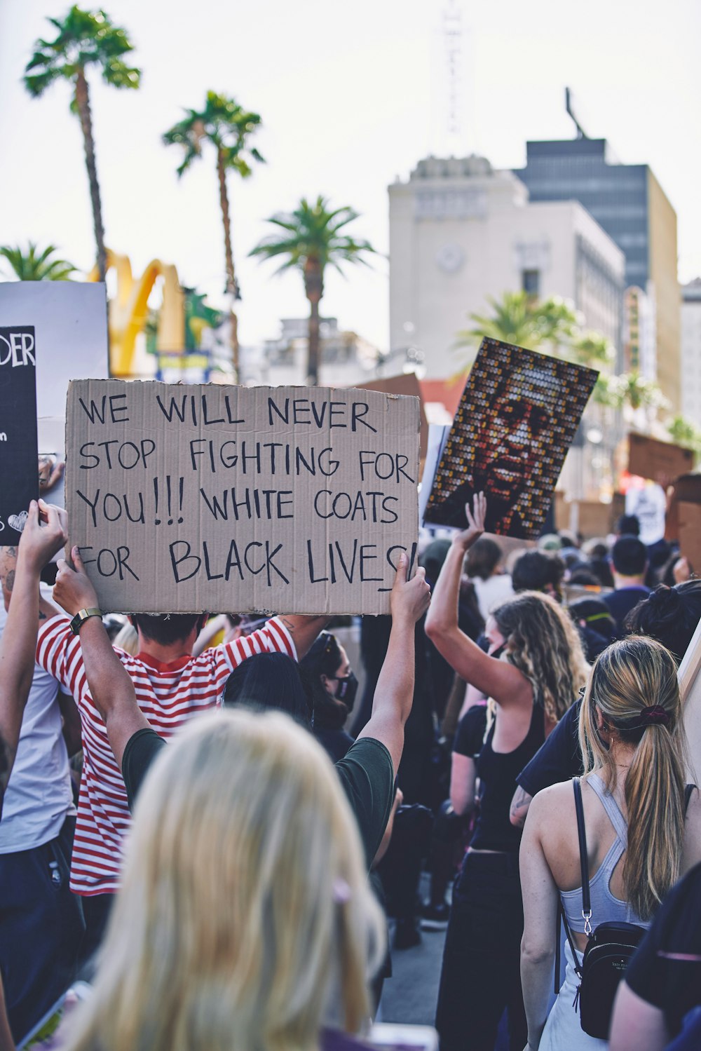 people holding black and white printed board during daytime