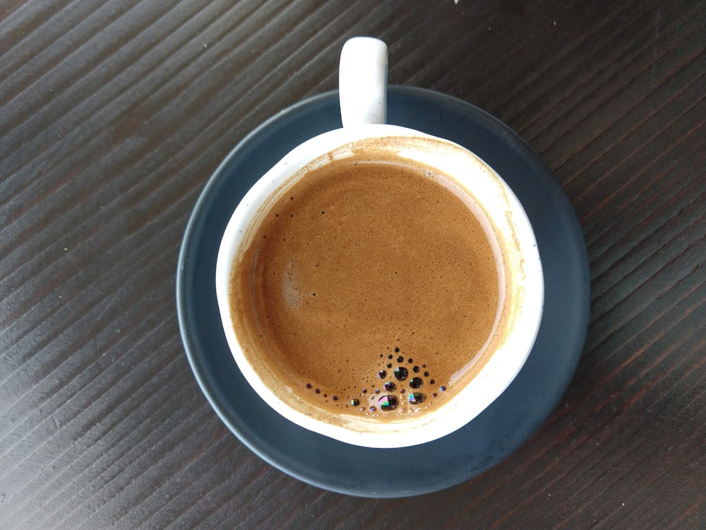 white ceramic mug with brown liquid