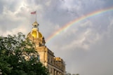 white concrete building under rainbow
