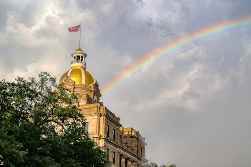 white concrete building under rainbow