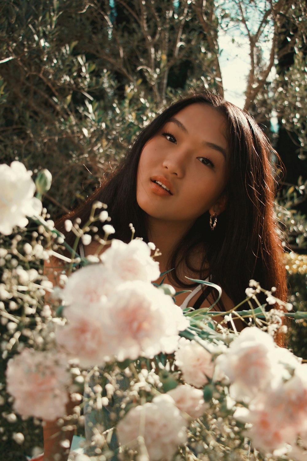 woman in white shirt holding white flowers