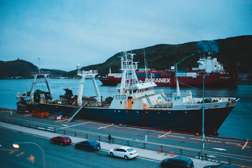 Wide shot of oceapure team preparing equipment on a dock with a large commercial vessel in the background.