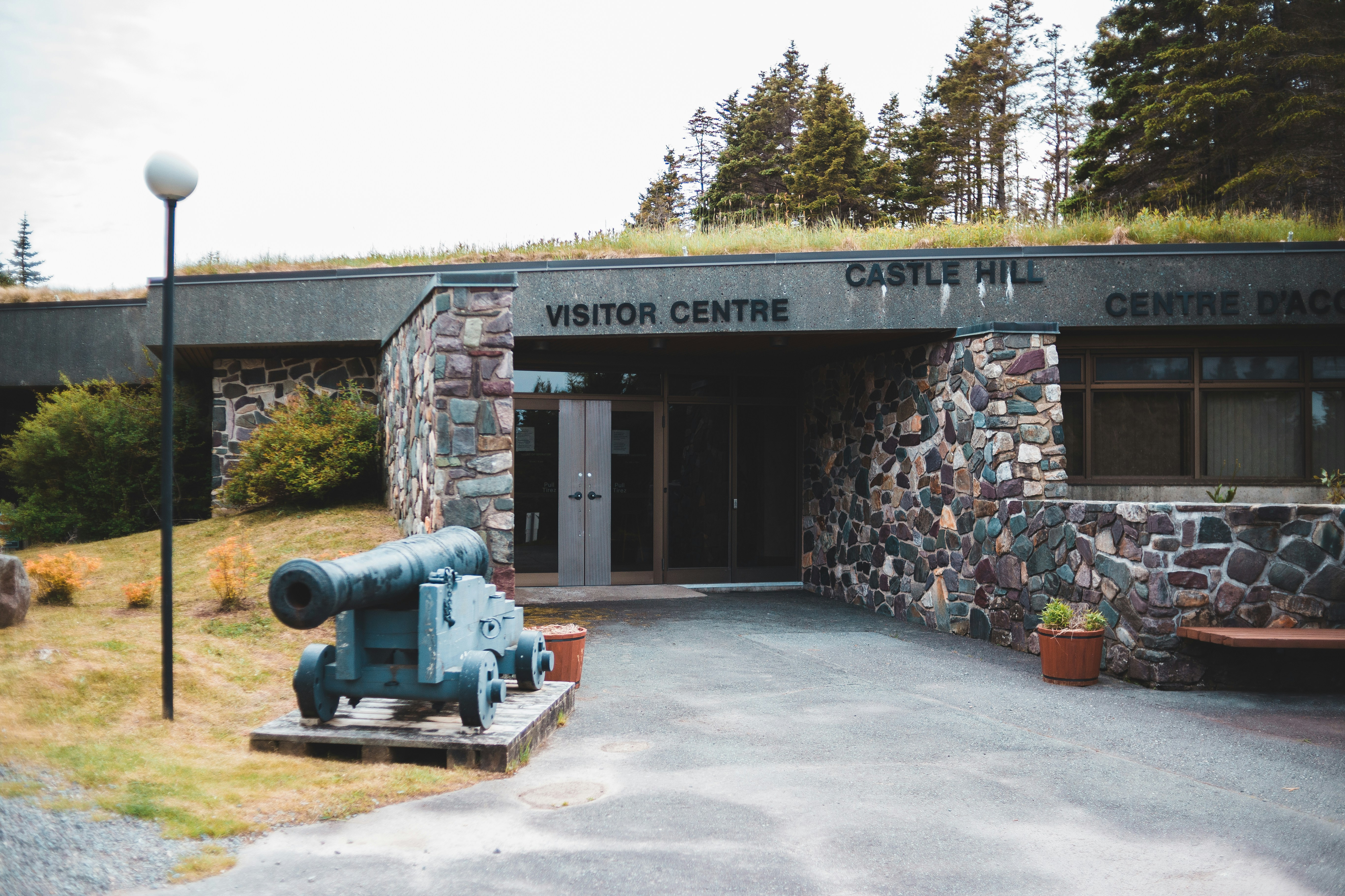 black canon statue near brown brick building during daytime