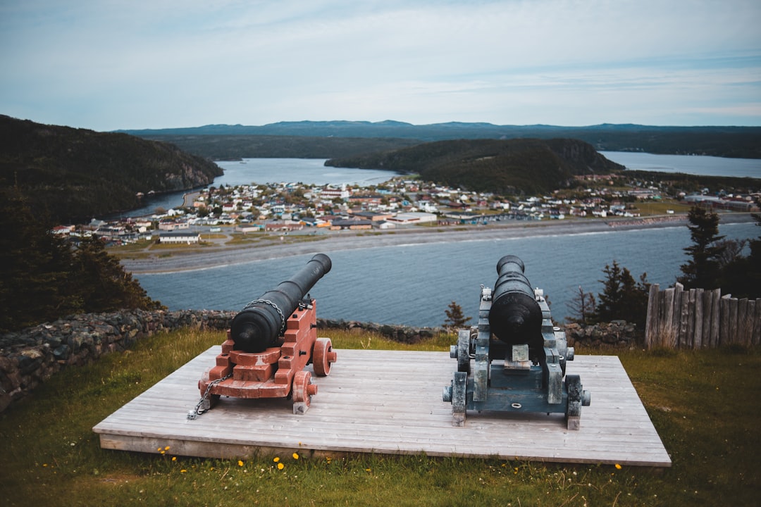 black and red canon on white concrete dock during daytime