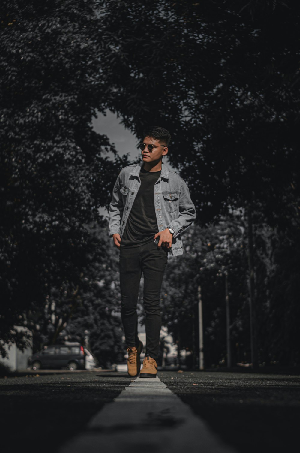 man in gray jacket and black pants standing on road during daytime