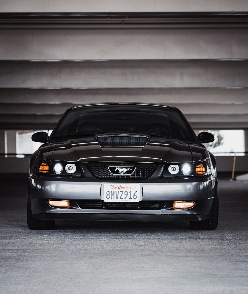 black bmw car parked beside white wall