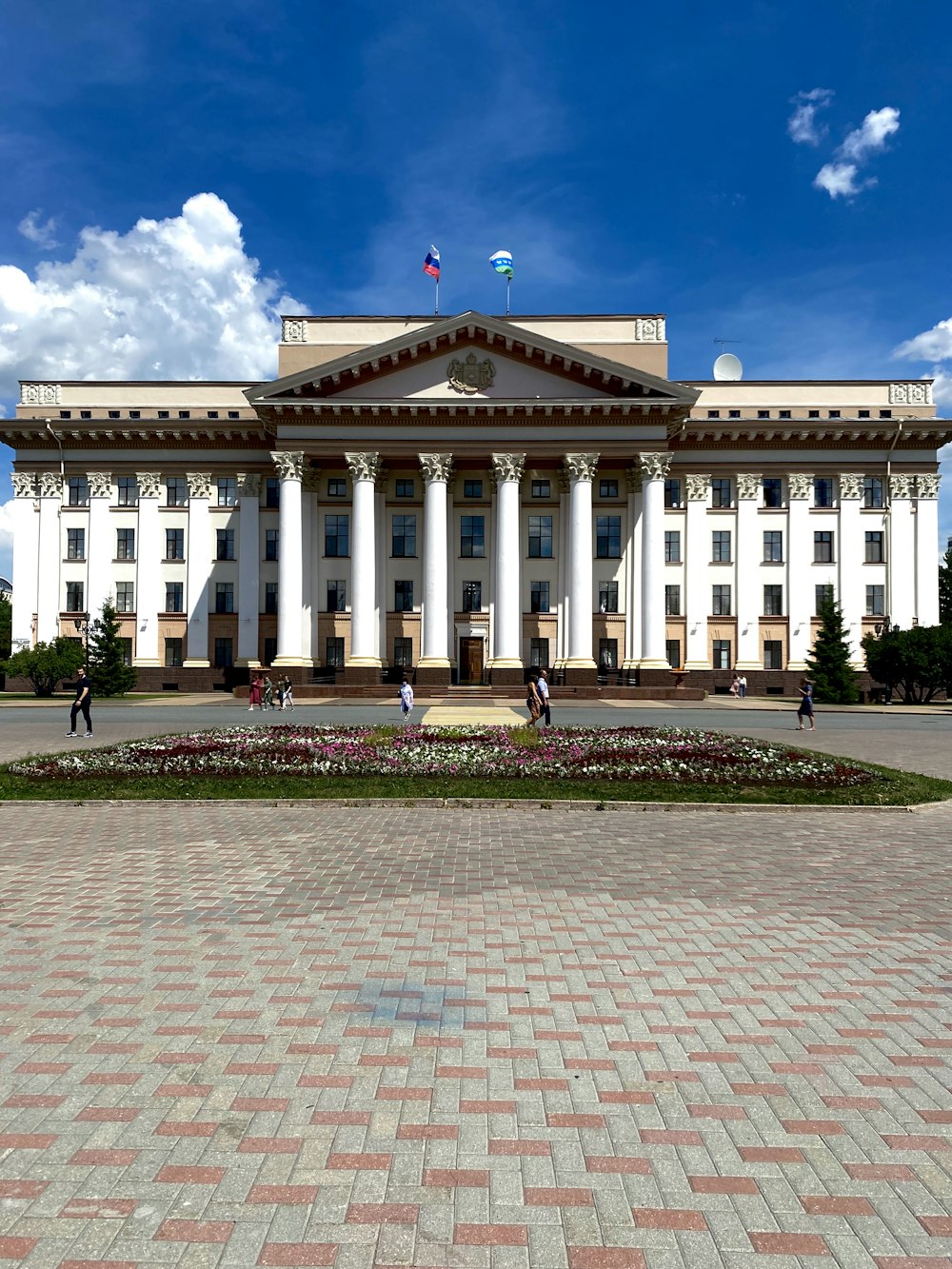 Weißes Betongebäude unter blauem Himmel tagsüber