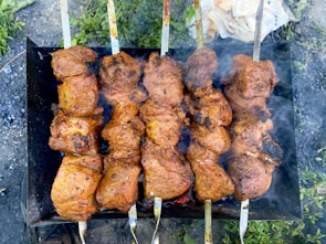 Grilled skewers of juicy BBQ meats sizzling over hot coals.