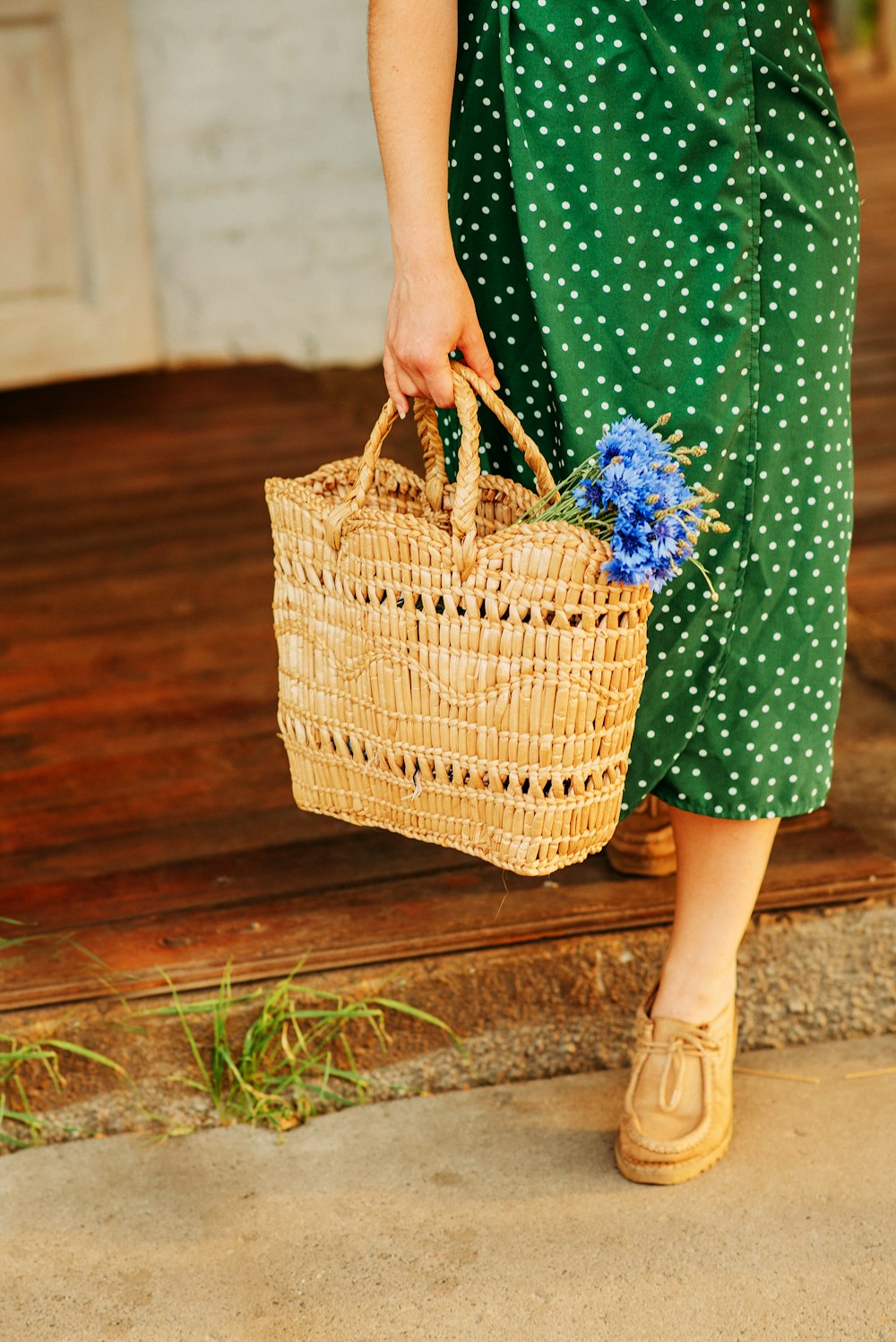 woman in green dress holding brown woven basket