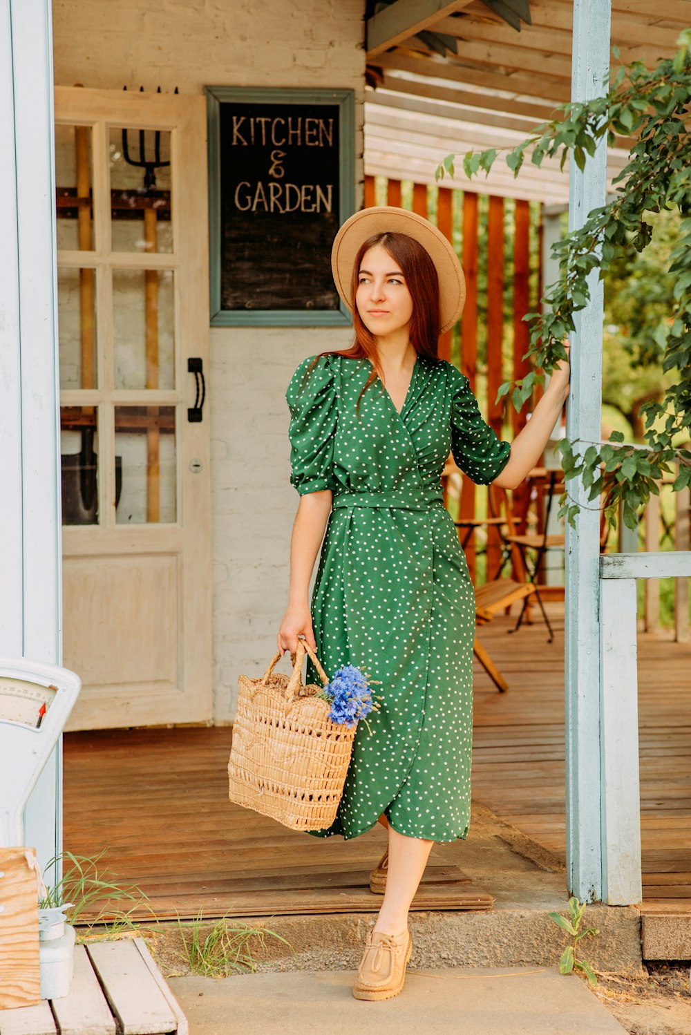 Femme en robe verte et blanche tenant un panier tressé marron