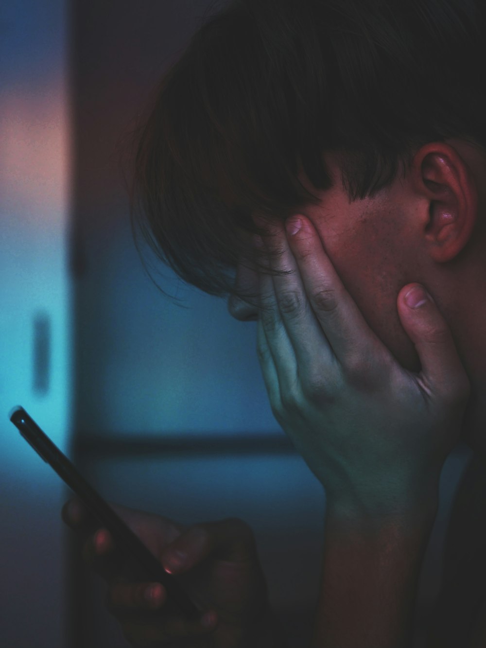 man holding smartphone in close up photography