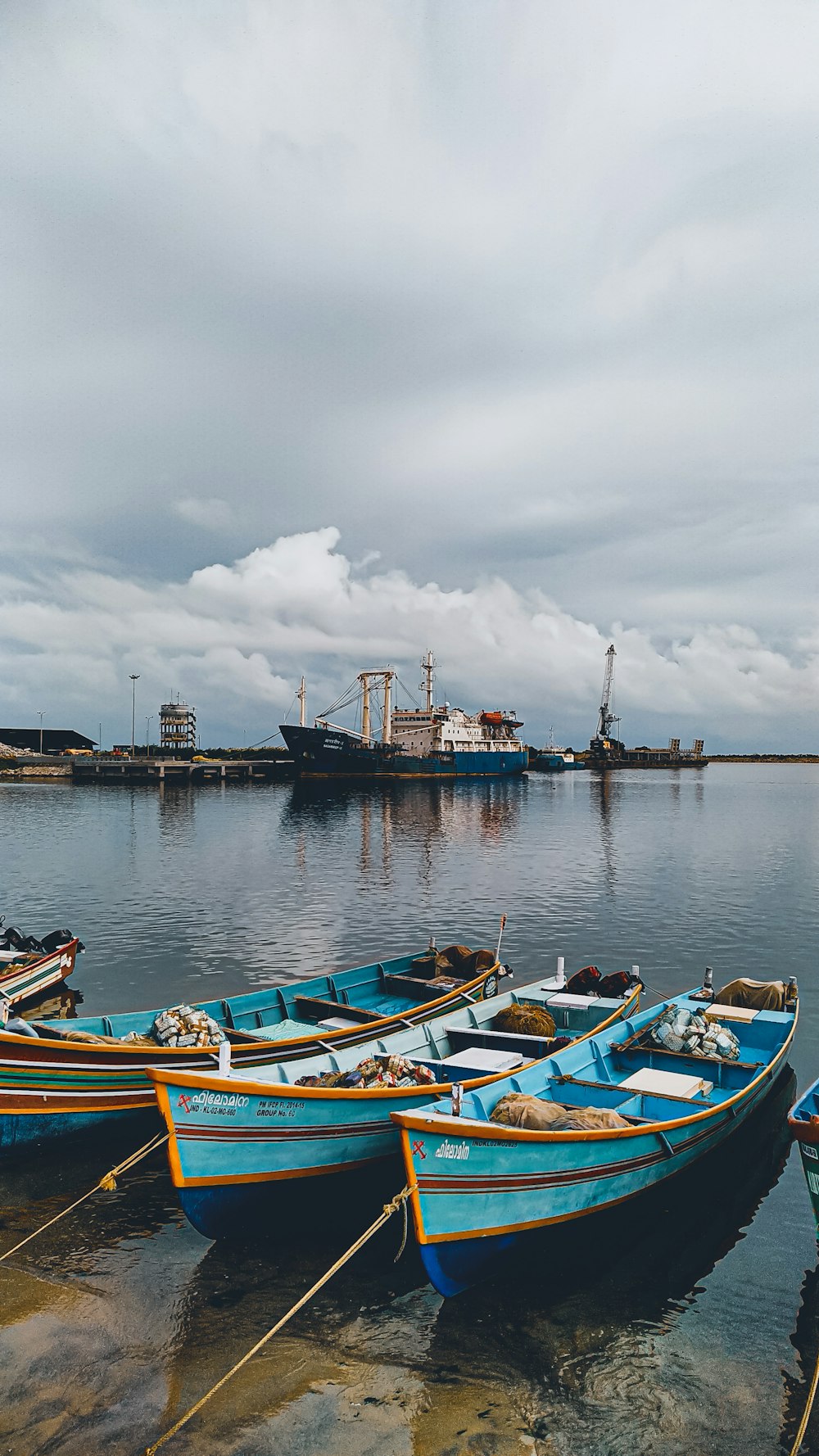 blue and white boat on body of water under cloudy sky during daytime