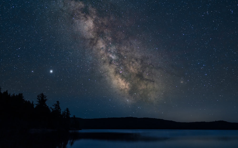 Cuerpo de agua bajo la noche estrellada