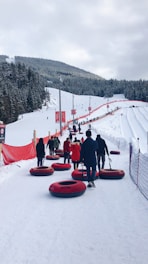 people sitting on red sled on snow covered ground during daytime