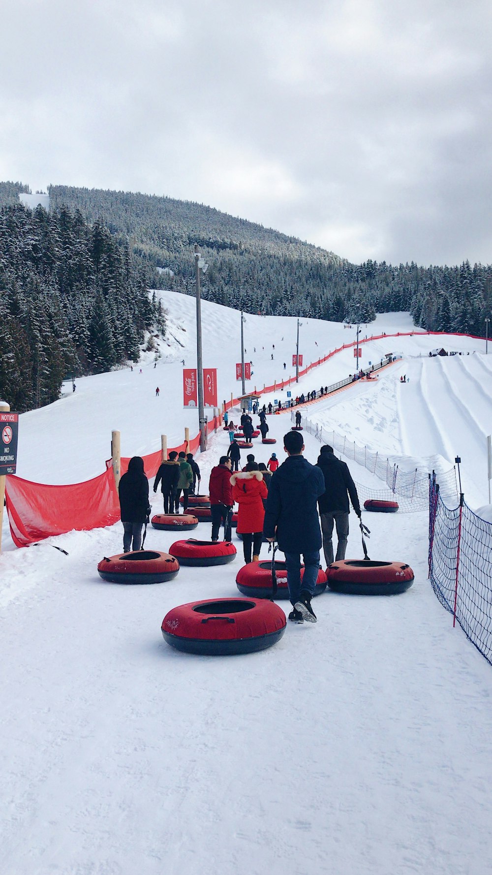 pessoas sentadas em trenó vermelho no chão coberto de neve durante o dia