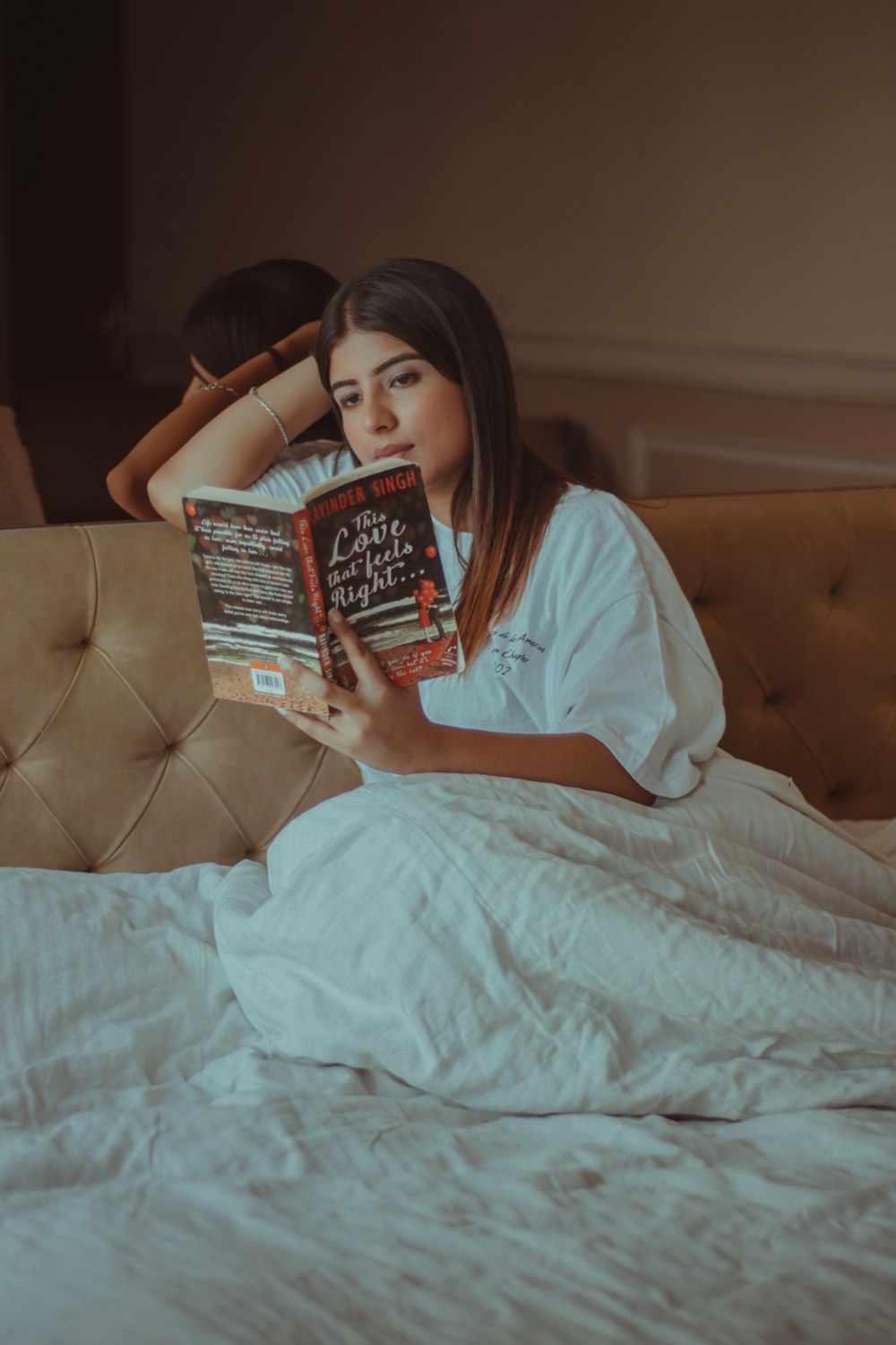 woman in white shirt holding book
