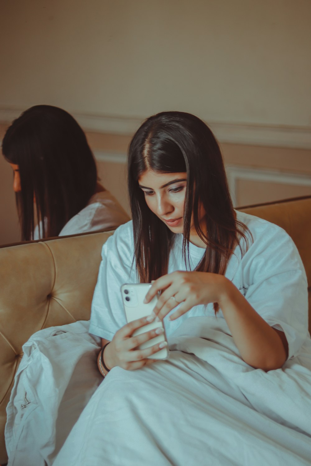 woman in white shirt sitting on couch