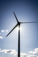 A wind turbine spinning against a clear blue sky.