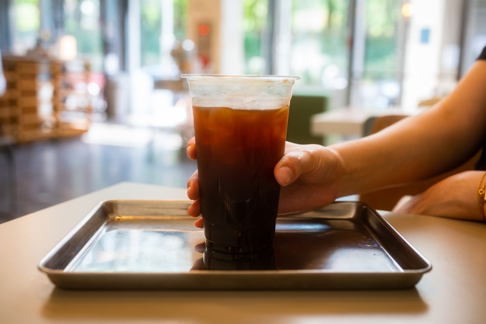 verre à boire transparent avec liquide brun