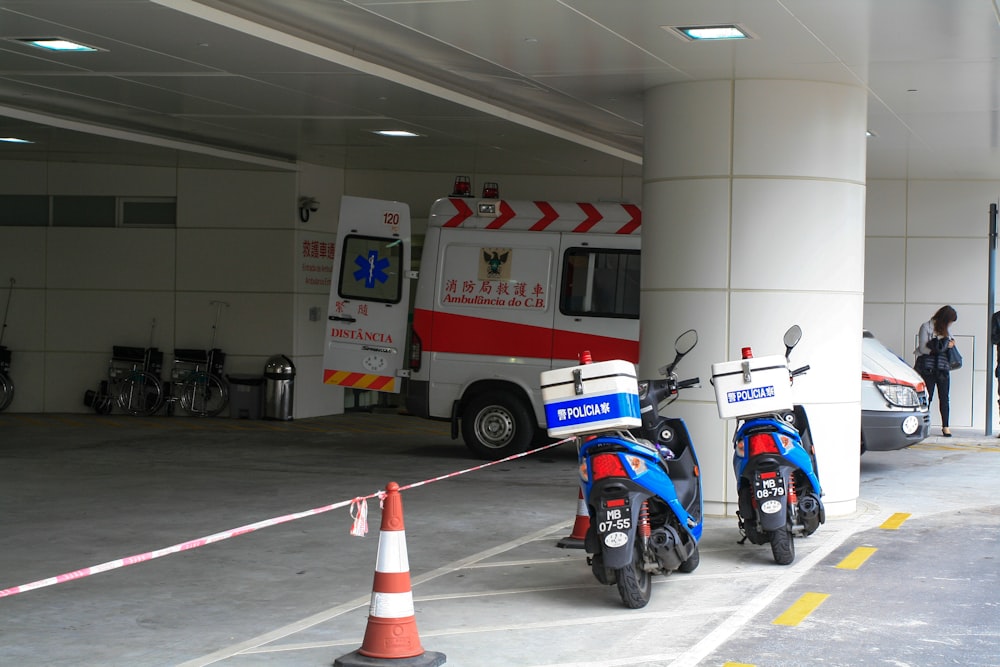 blue and white motorcycle parked beside white and red fire extinguisher