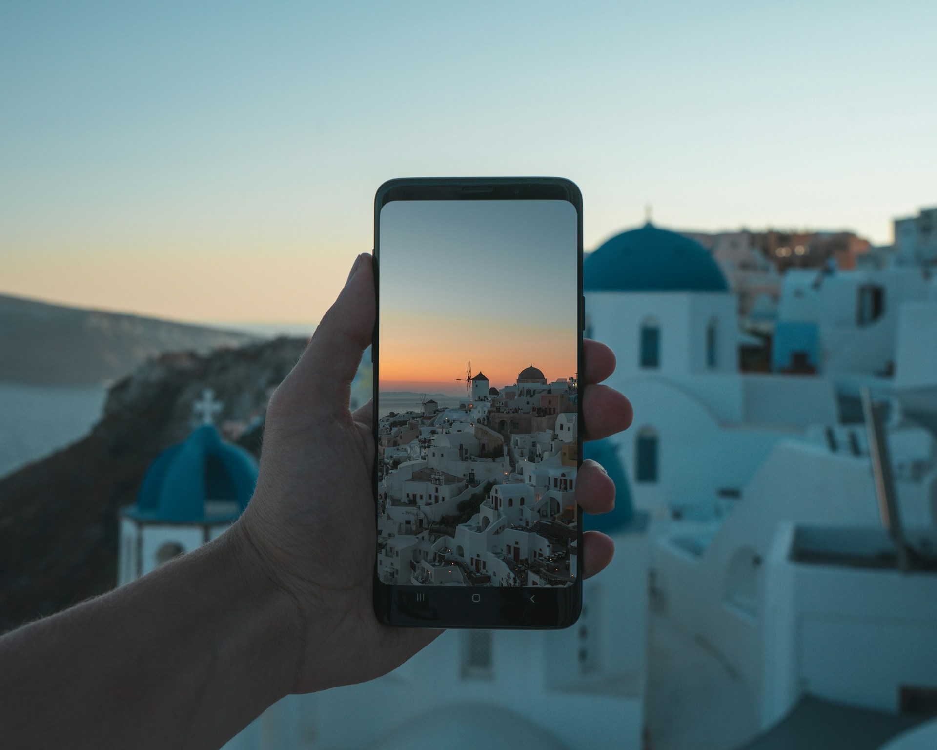 person holding black smartphone taking photo of city during daytime