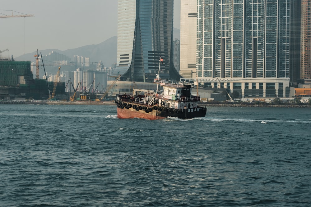 brown ship on sea near high rise building during daytime