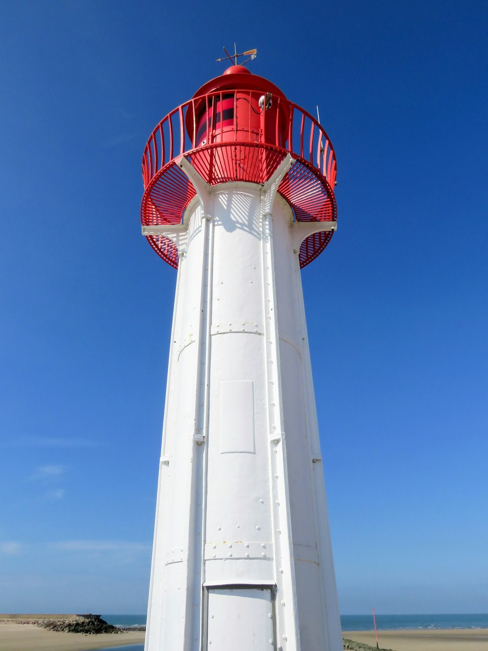 white and red lighthouse under blue sky during daytime