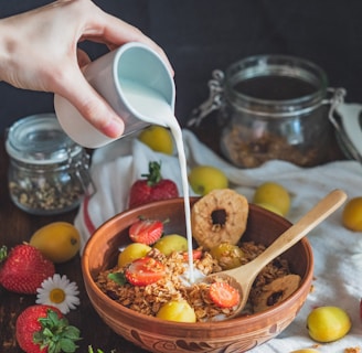 person holding white plastic spoon and brown wooden ladle