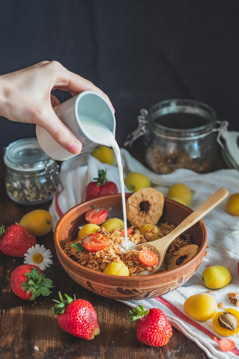 person holding white plastic spoon and brown wooden ladle