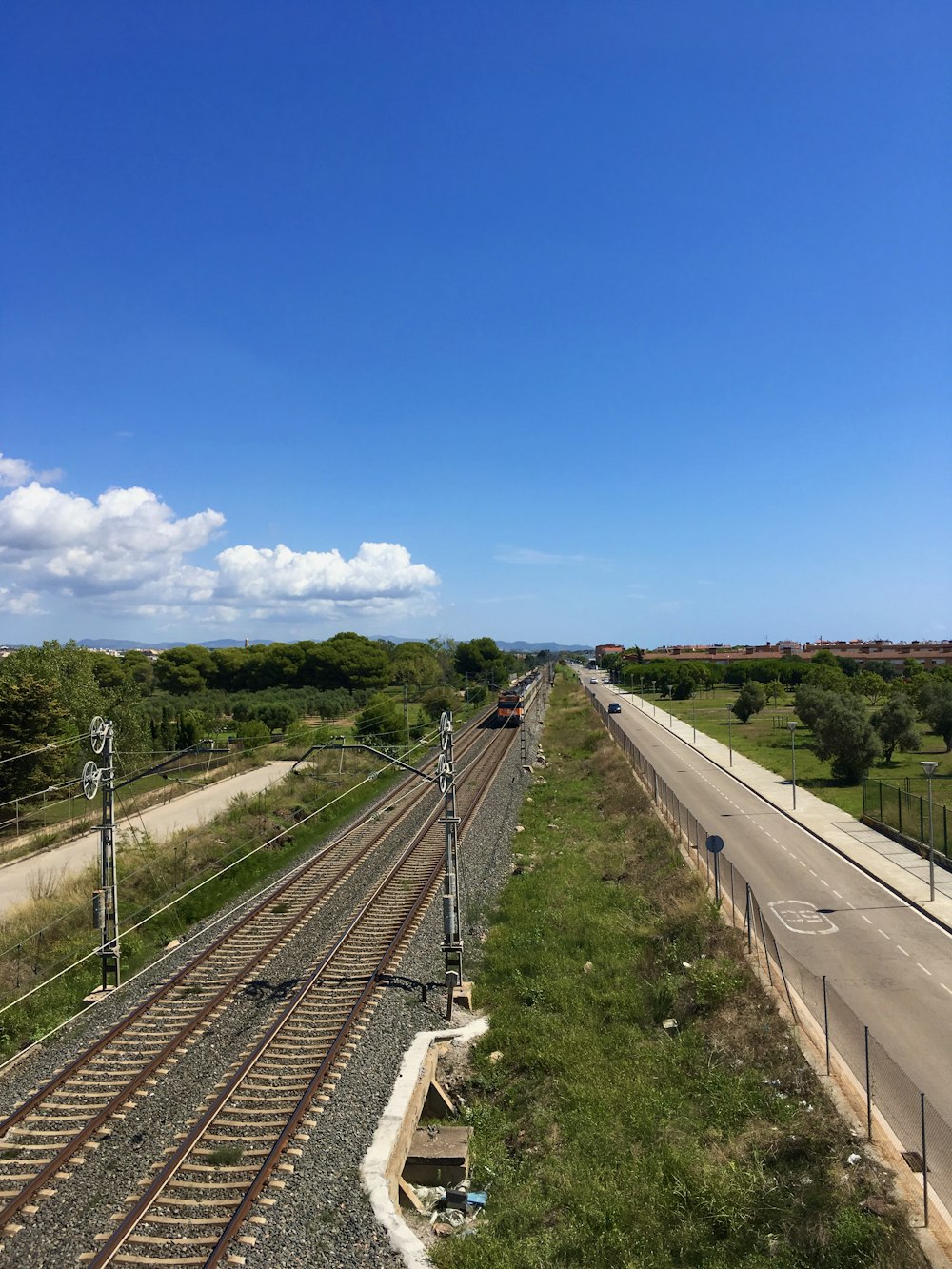 train rail under blue sky during daytime