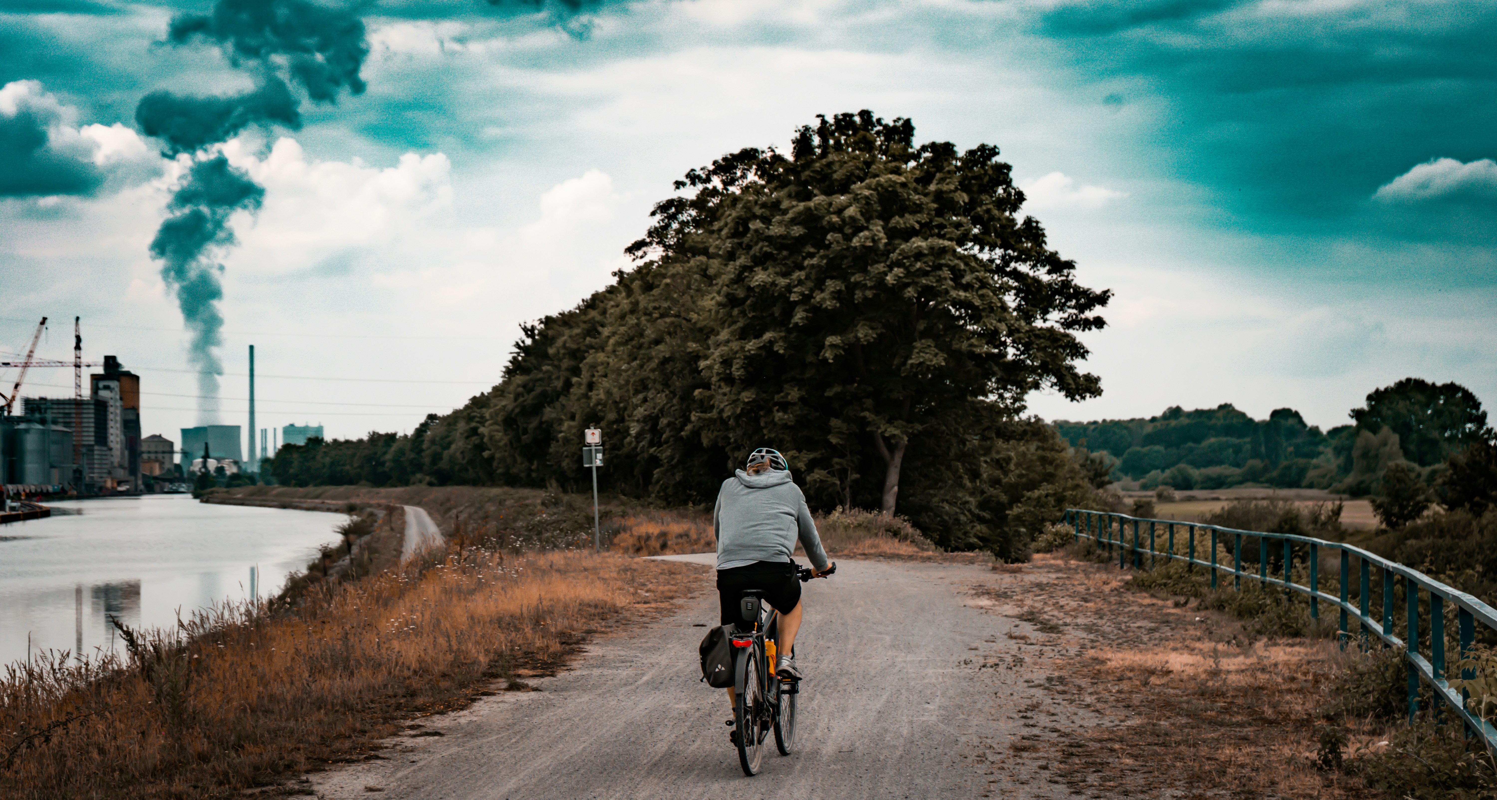 man in white t-shirt riding bicycle on road during daytime