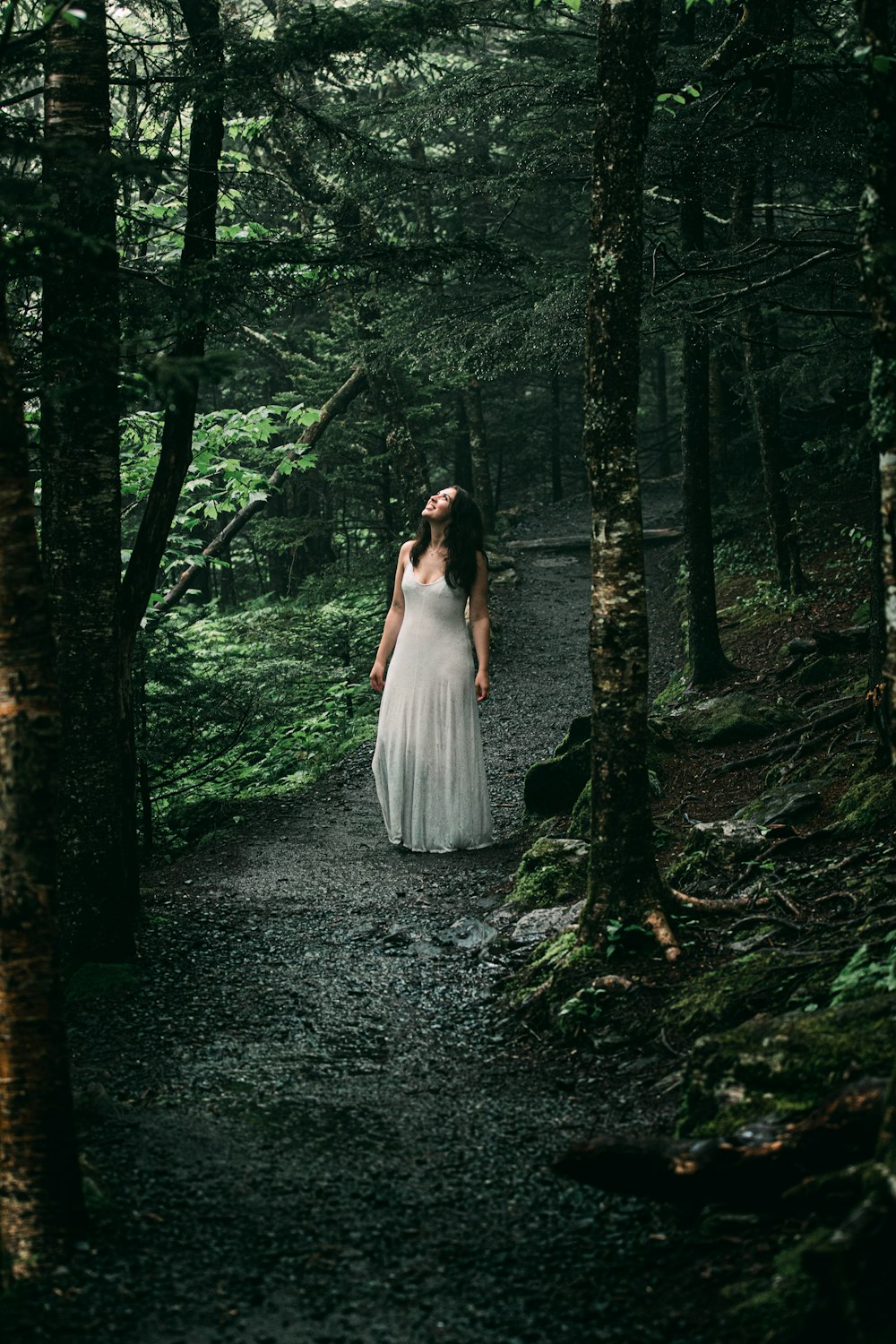 woman in white dress standing in the woods