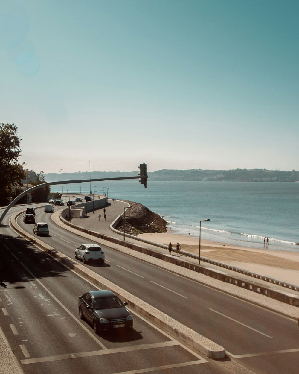 cars on road near body of water during daytime