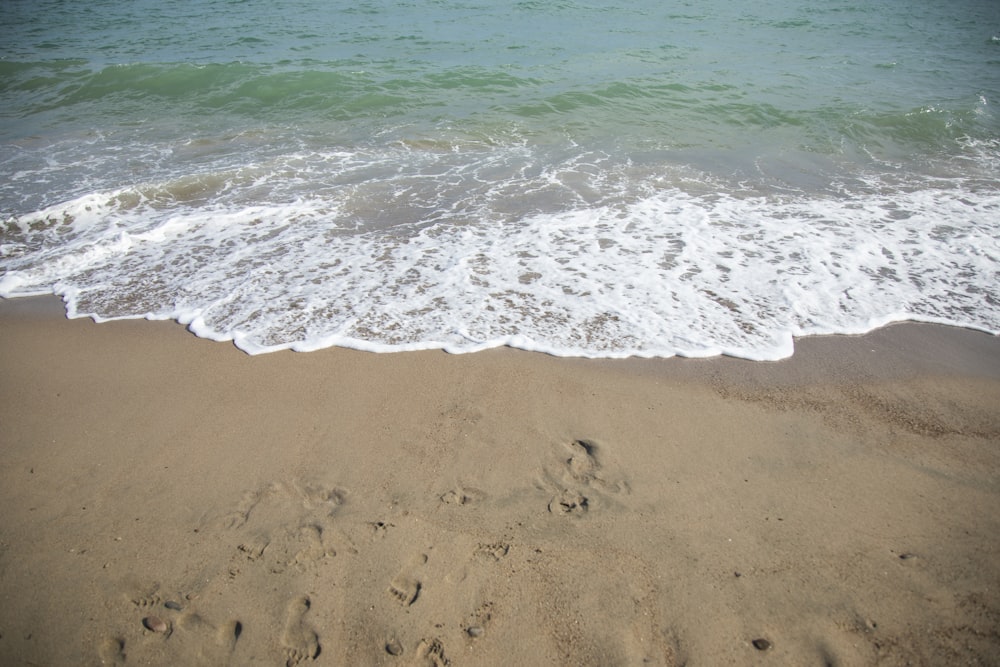 sea waves crashing on shore during daytime